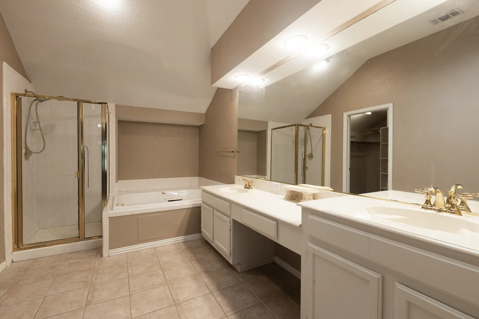 Azure Ln. primary bathroom in Addison before the renovation: beige tile and a gold-framed shower