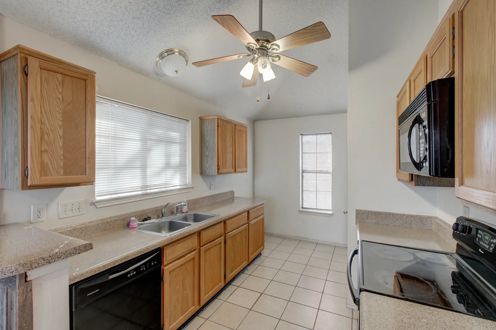 The same Haven Pl kitchen in Allen, TX before the pre-sale renovation: original oak cabinets and dated finishes
