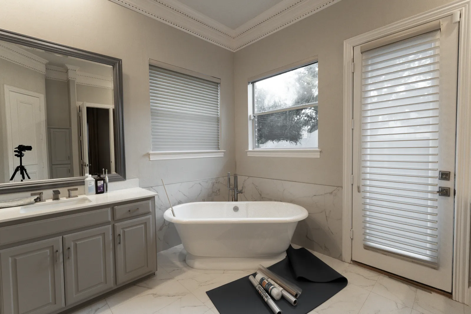 Prestwick Ln primary bathroom in Dallas before the renovation: gray vanity and original tub