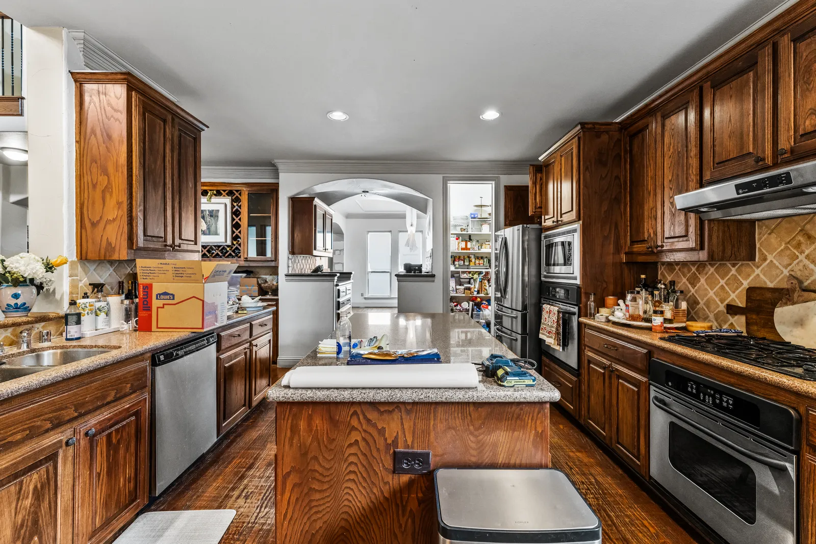 Shady Point Dr kitchen in Plano before the remodel: dark cherry cabinets and the original island
