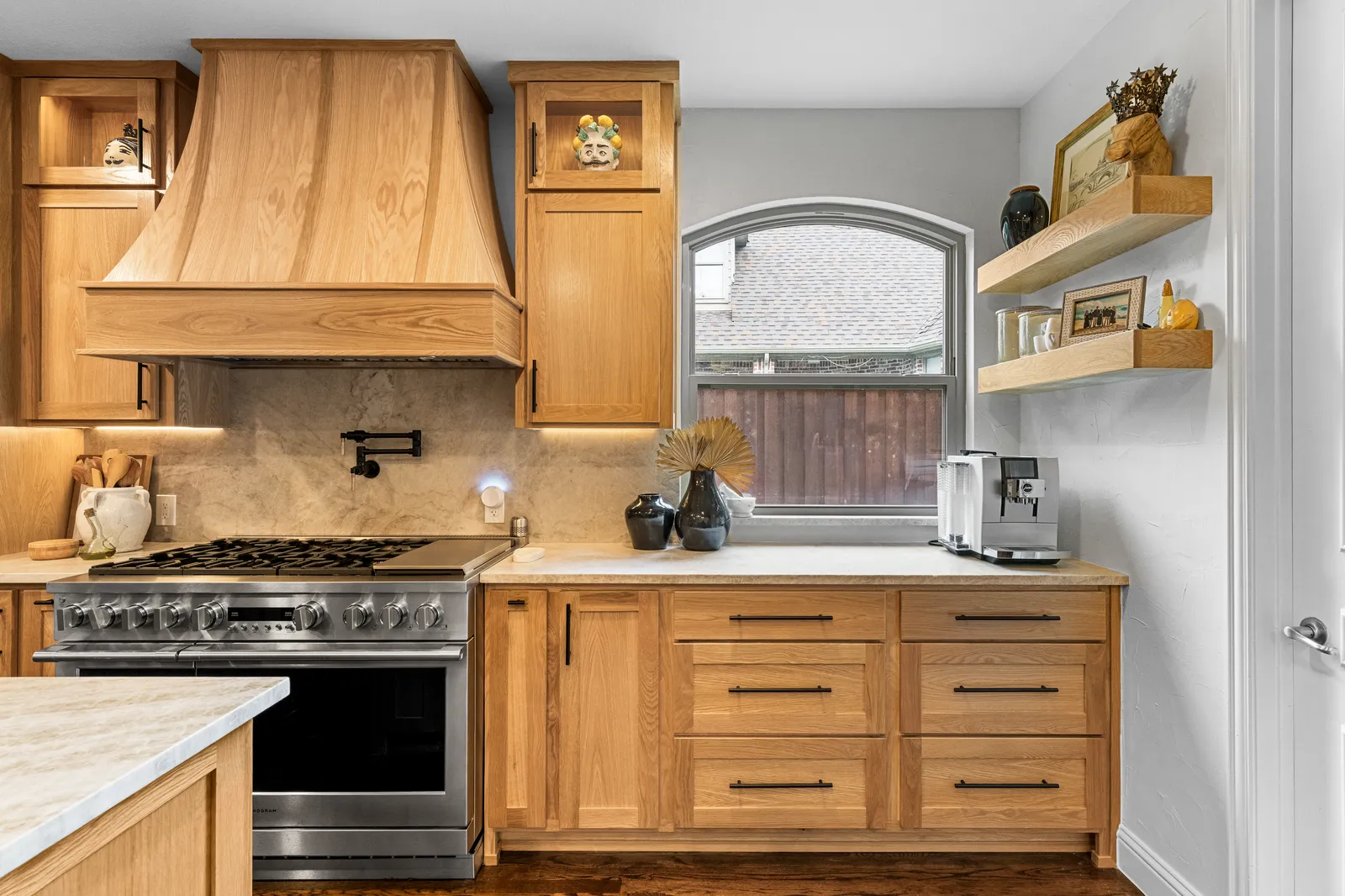 Plaster range hood and pro range in the remodeled Shady Point Dr kitchen in Plano