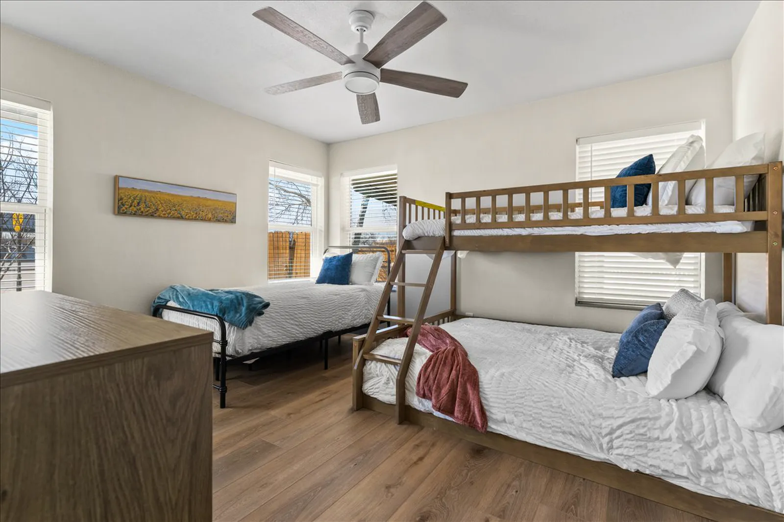 Bunk room with new flooring, paint, and lighting at Sherman St. in McKinney