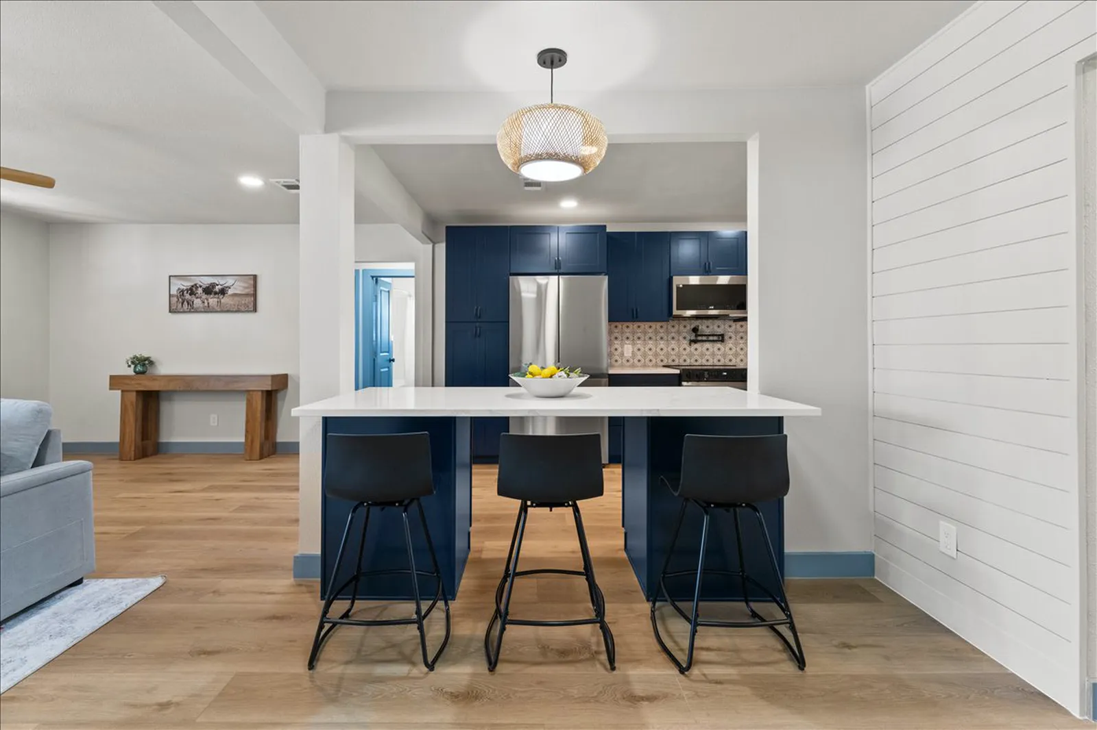 Kitchen island with seating and a rattan pendant at Sherman St. in McKinney