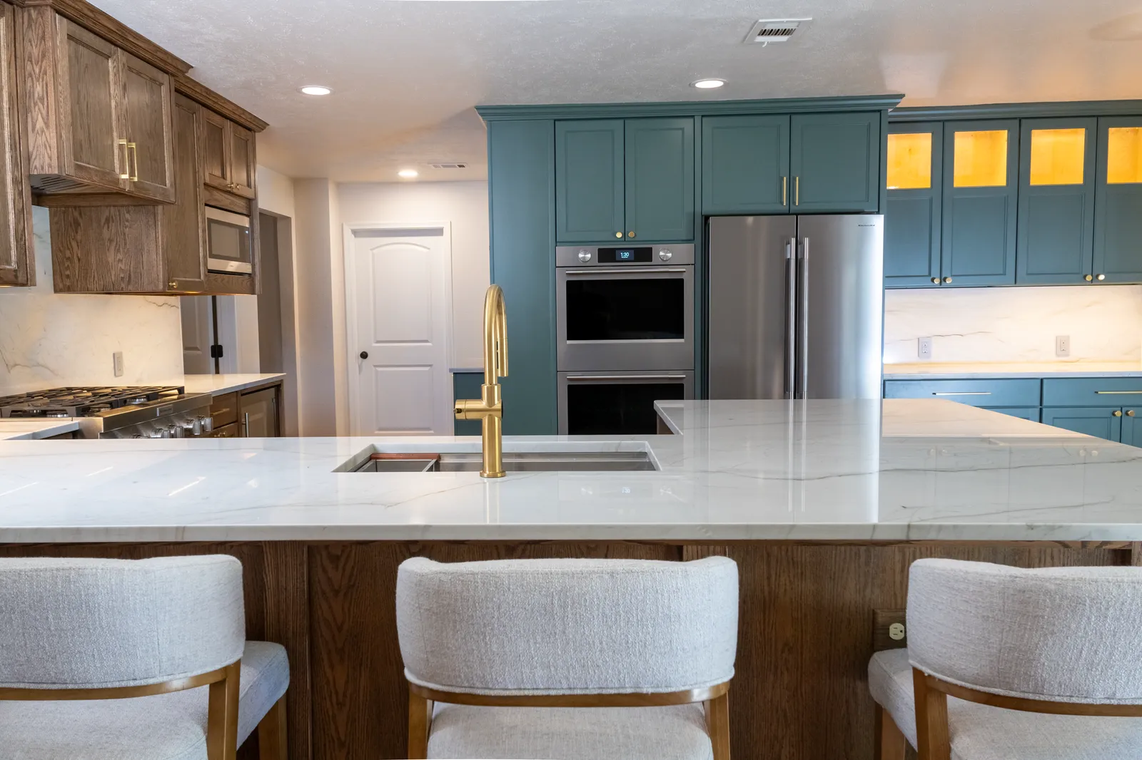 Island seating and green-painted pantry cabinets at Vancouver Dr. in Preston Hollow