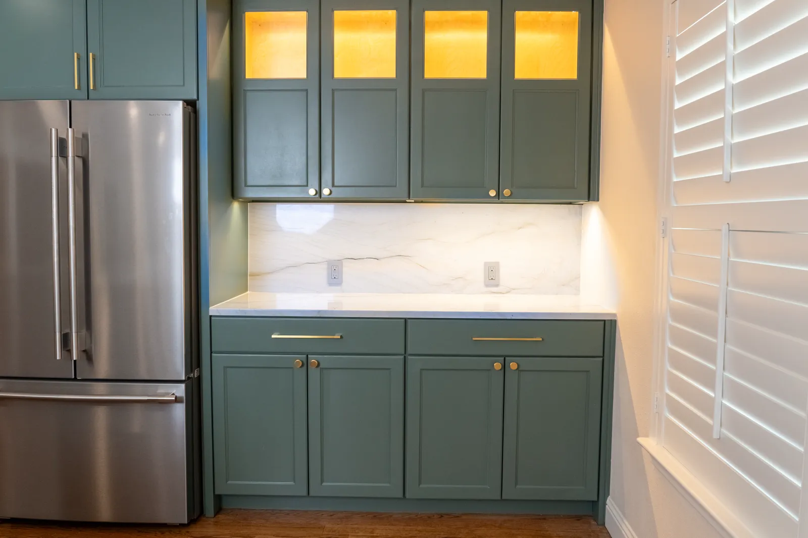 Green painted cabinets with lit glass uppers at Vancouver Dr. in Preston Hollow